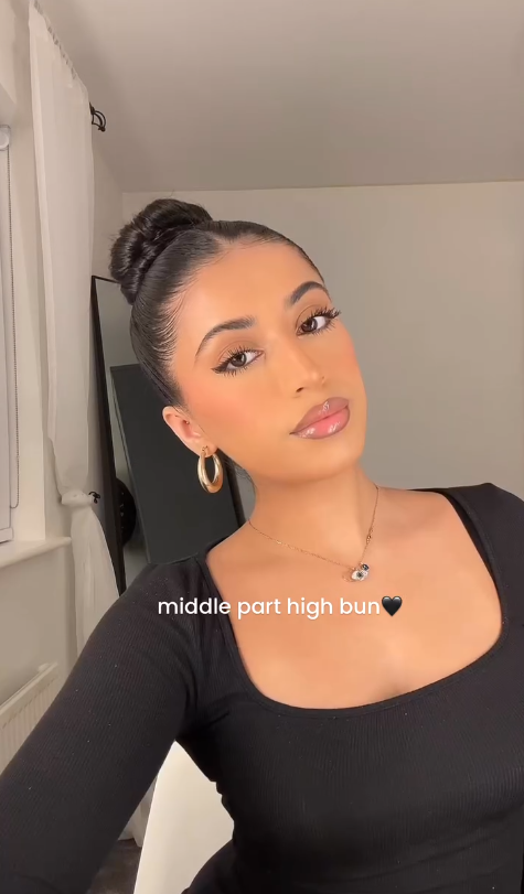 Middle part glossy bun hairstyle with a polished high bun look