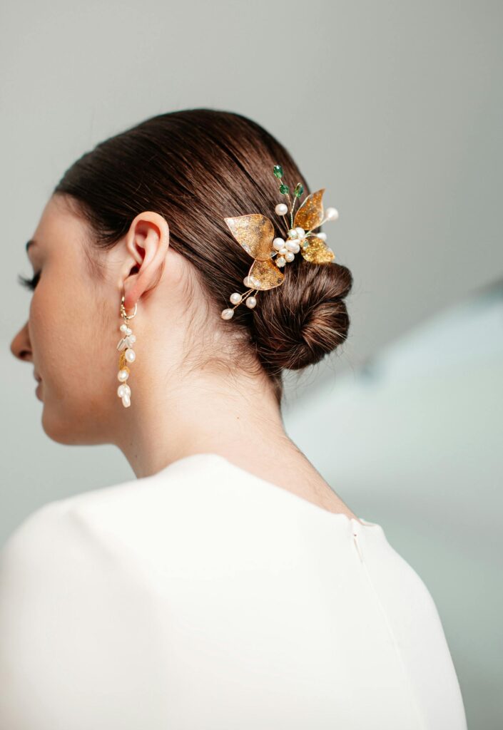 Sleek low old money bun hairstyle with elegant pearl accessories