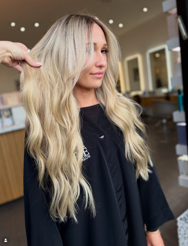 Creamy blonde long layers with soft waves create a bright, soft, and elegant hairstyle.