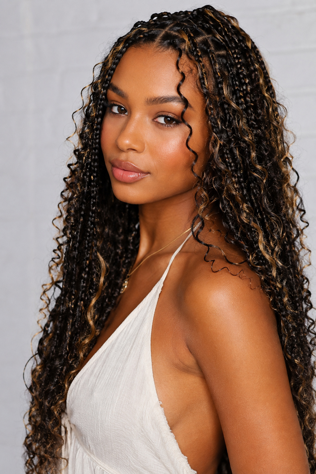 Goddess braids combine defined braided sections with generous curls, creating a rich style full of movement and dimension.